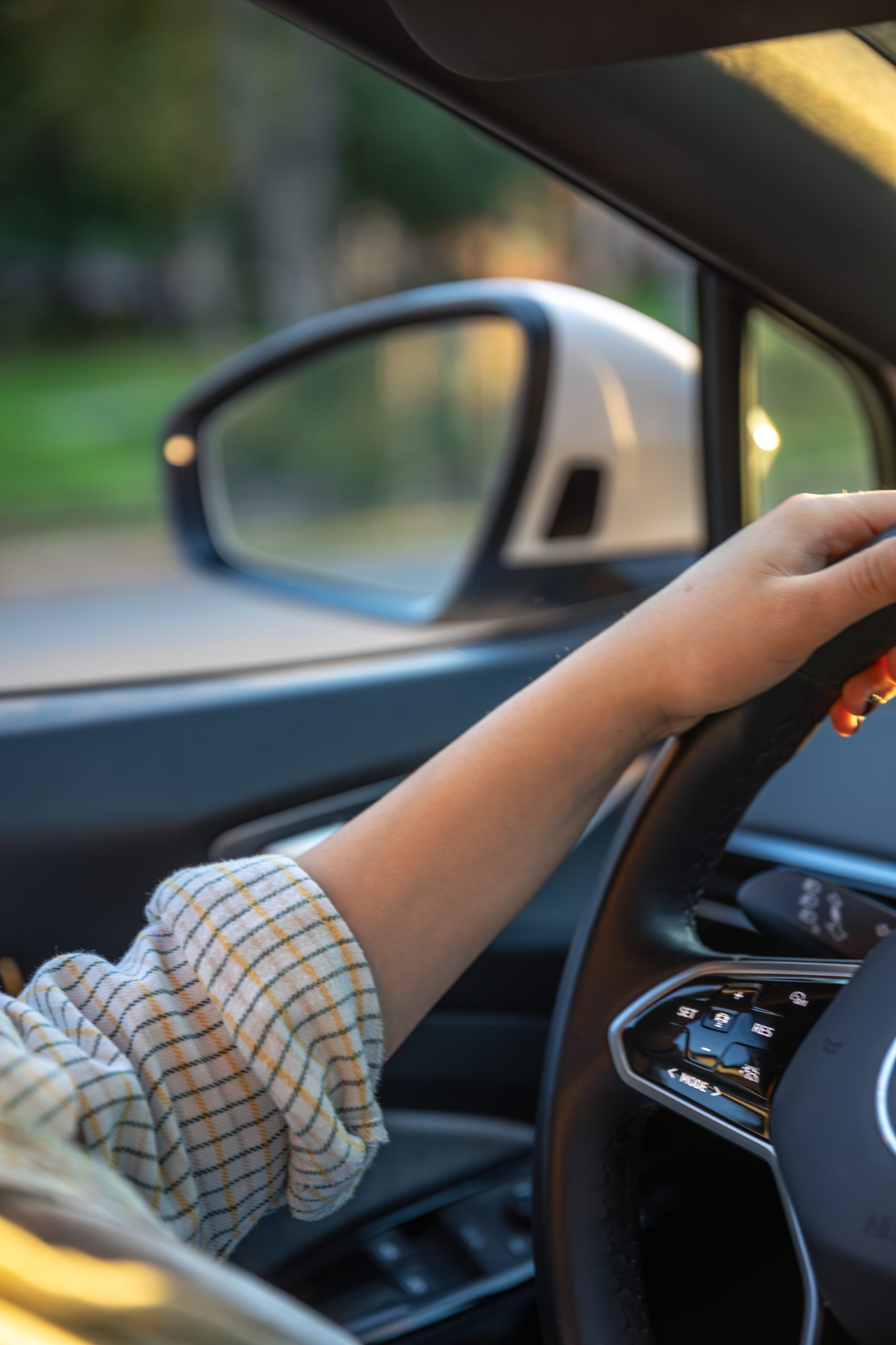young woman driving car hands wheel side mirror car scaled